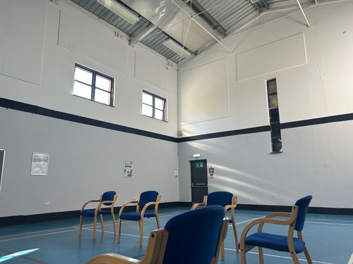 large hall with tables, chairs and presentation setup