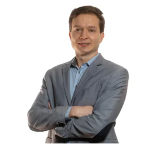 A person in a suit with his arms crossedAI-generated content may be incorrect.