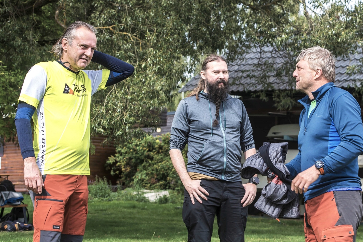 Three colleagues talking in a garden by the lake
