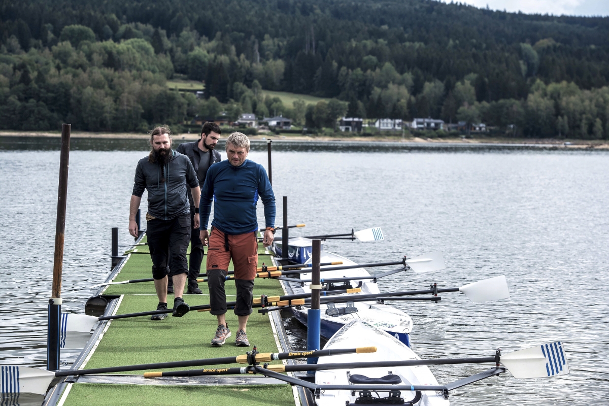 Colleagues on a jetty next to rowing boats at Lipno