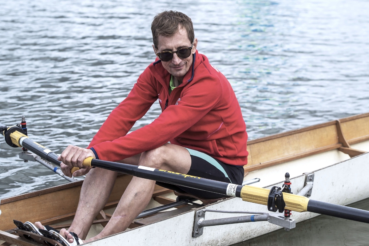 Colleague in a red jacket sitting in a rowing boat