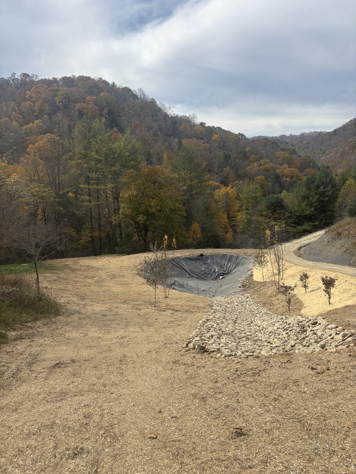 Prepared pond with installed liner and a stone-lined approach