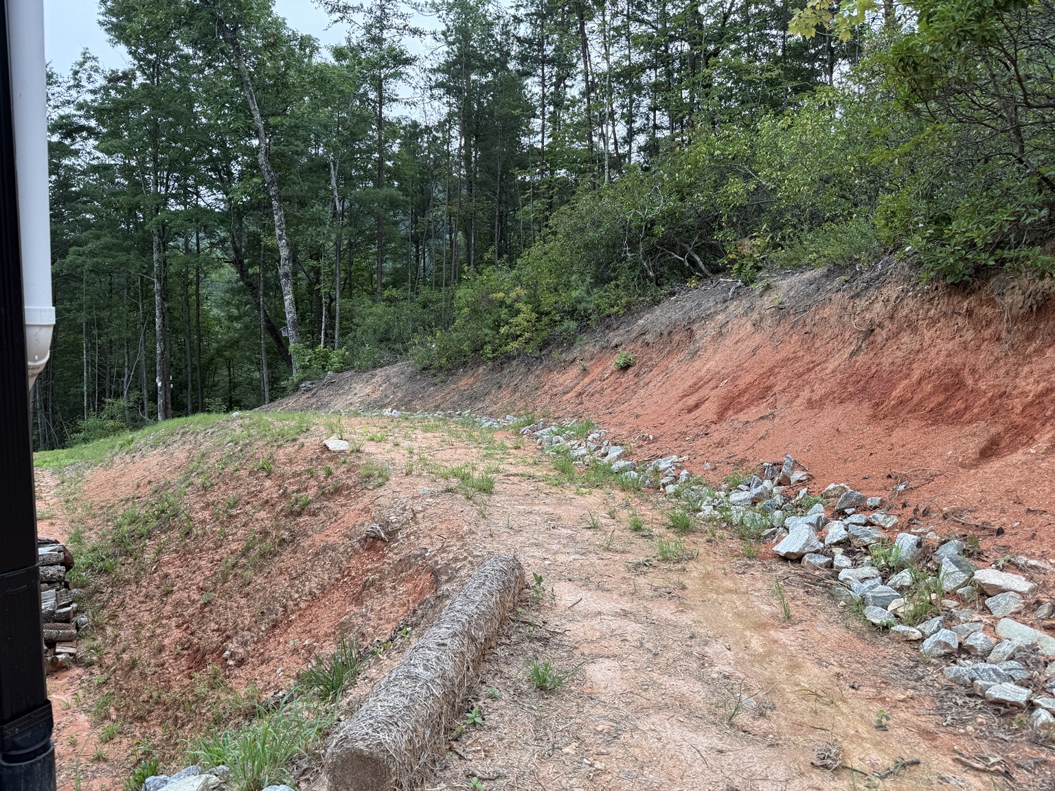 Eroding red clay bank and drainage channel before the Ferguson erosion control project