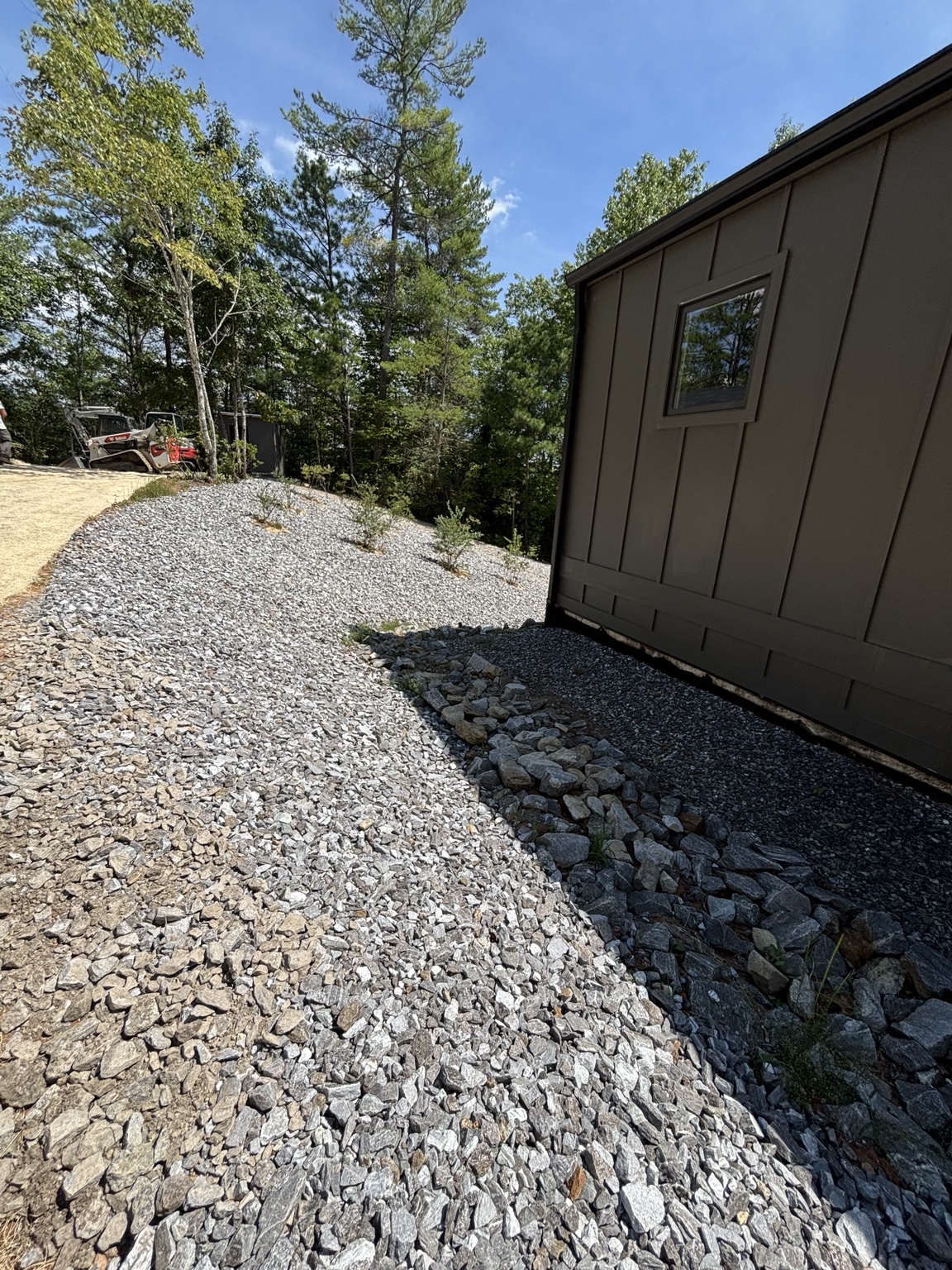 Clean stone drainage and riprap protection beside the home