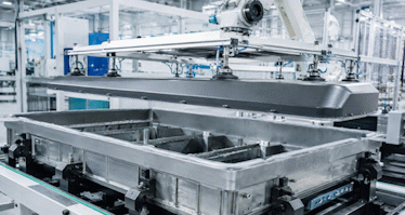 Metal components being assembled or inspected in a clean, automated factory setting.