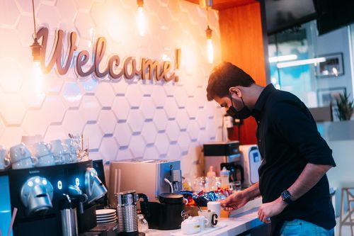 a man standing in front of a coffee machine