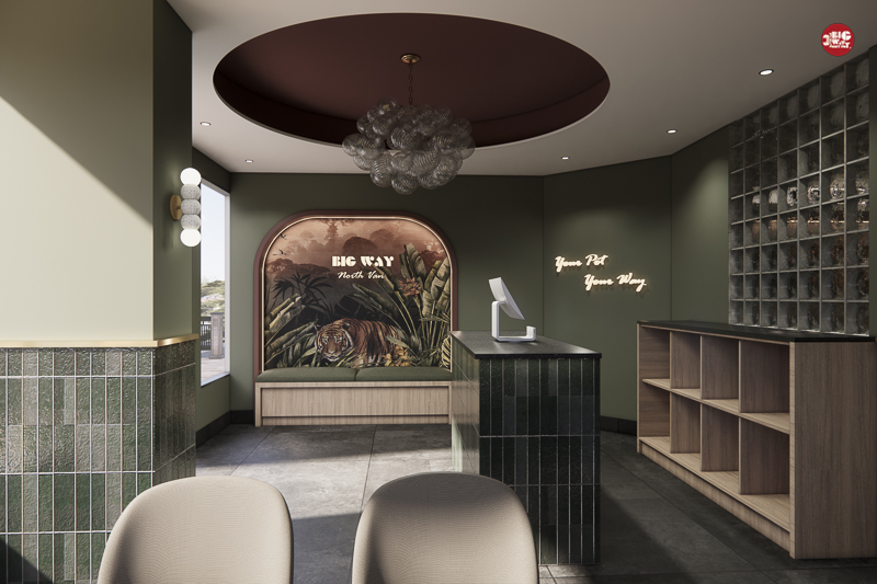 Modern reception area with dark green tiled counter, wooden shelves, a circular ceiling feature with chandelier, and a tiger mural reading 'BIG WAY North Van' on the back wall.