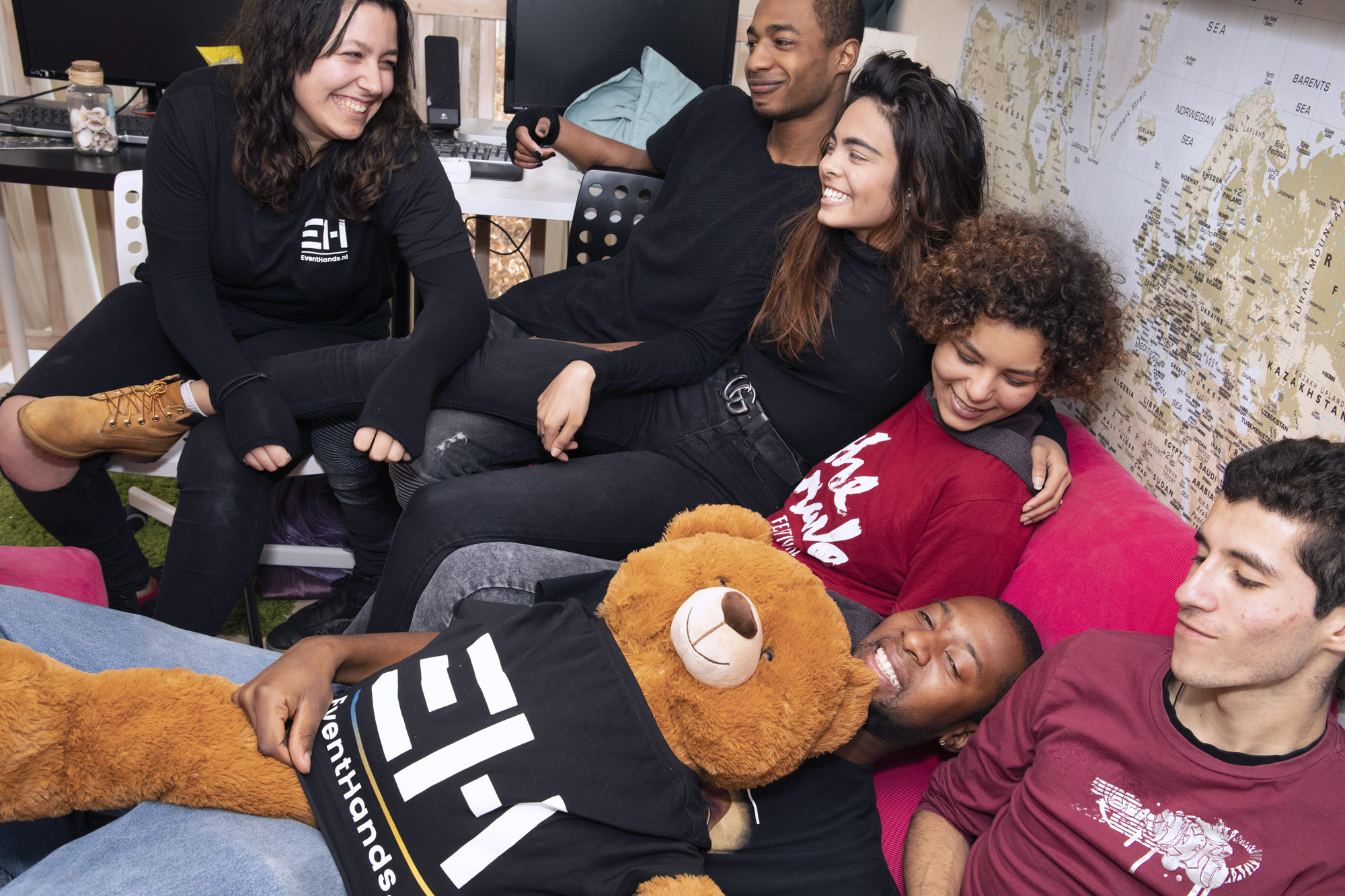 Foto van een groep MDT deelnemers die samen vrolijk lachend hangen op de bank