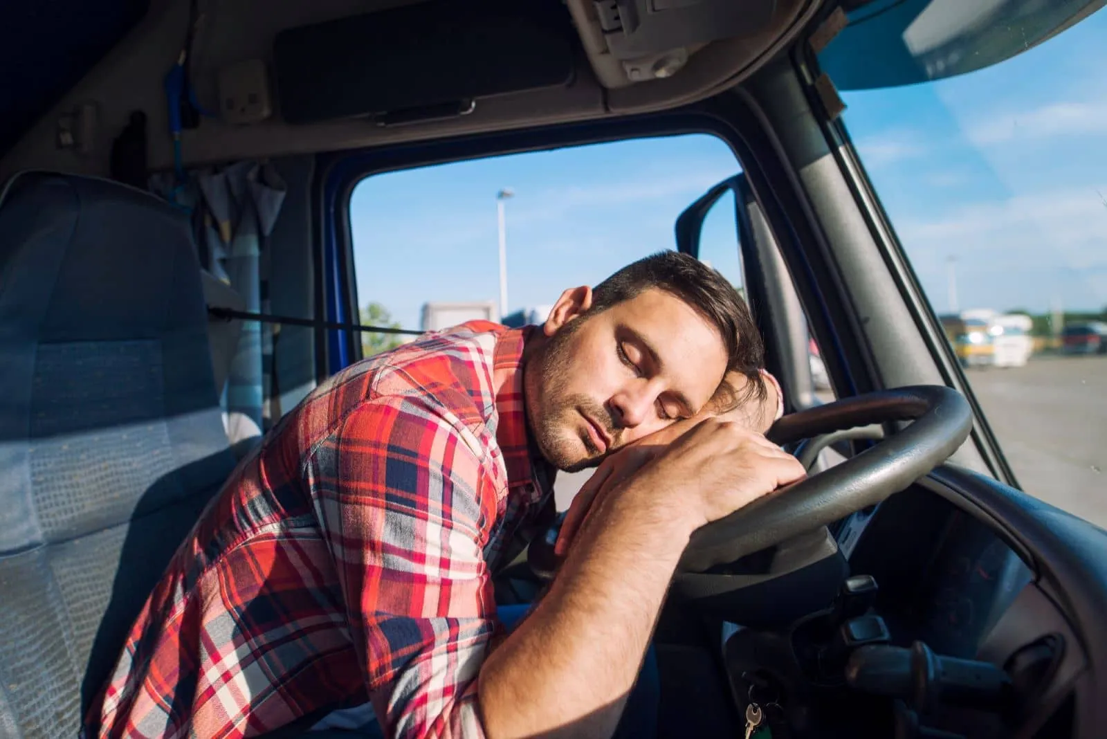 Truck driver resting in a sleeper cab after a long day on the road, highlighting safe rest options for truckers.