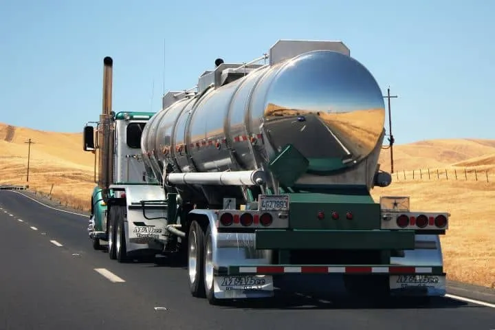Hazmat semi-truck transporting a specialized load on the highway.