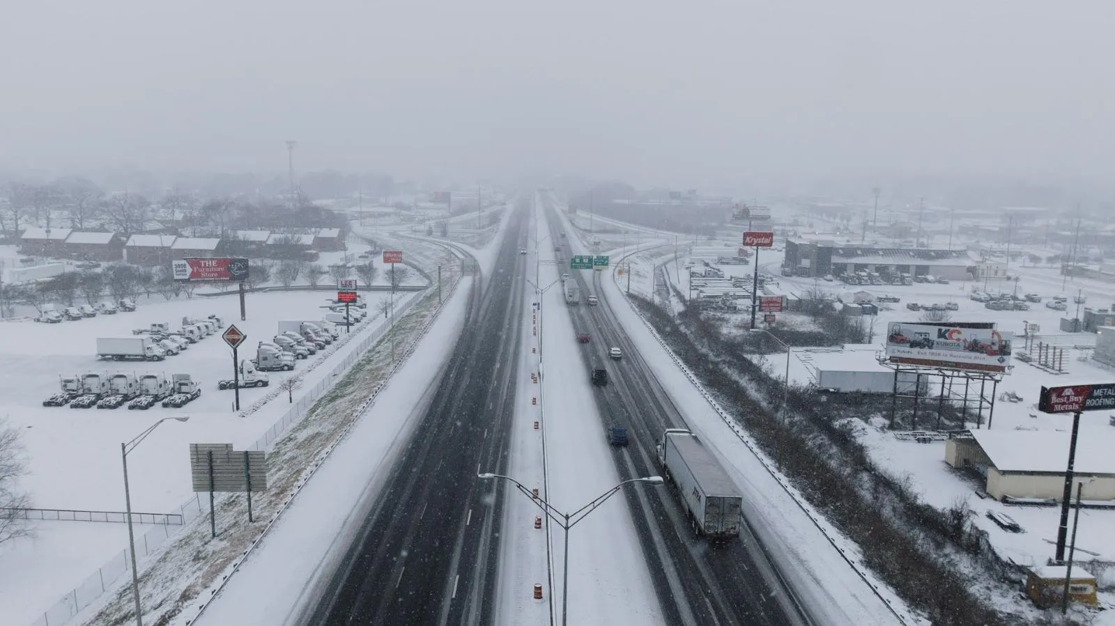 Semi-truck driving on a snowy, icy road during winter, highlighting safe winter driving conditions.