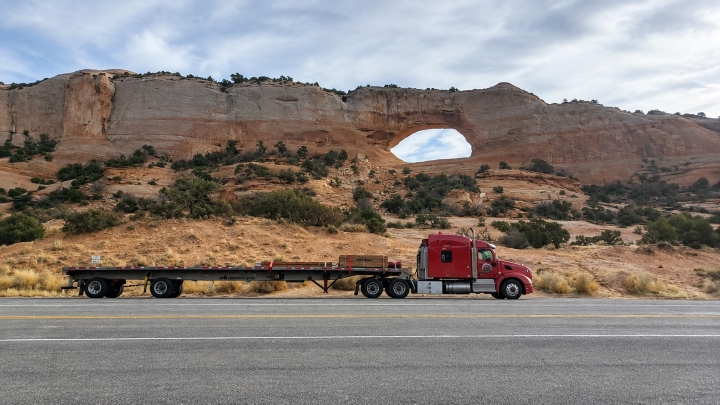 Red semi‑truck by desert arch, highlighting mistakes new drivers must avoid.