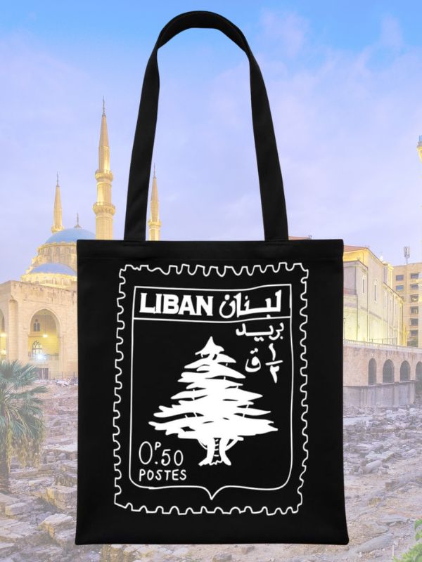 Black tote bag with a white design of a vintage Lebanese postage stamp featuring a cedar tree.