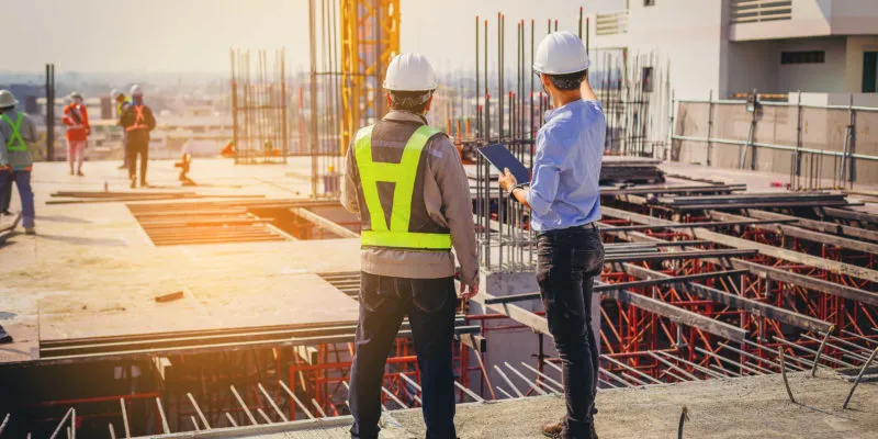 A worker and a supplier at a construction site.