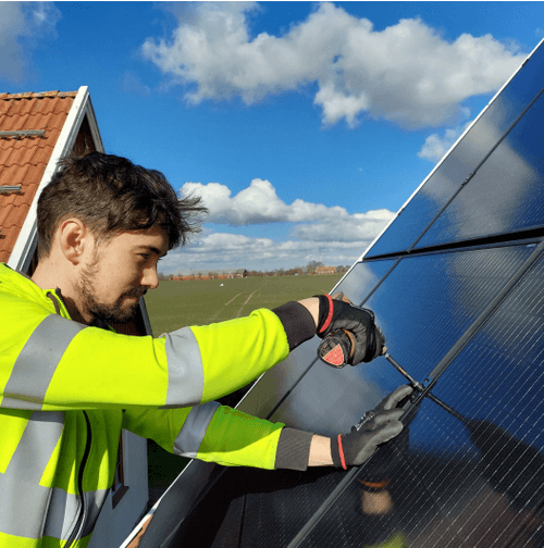 Kvarnerup Elektriska elanläggnings service. En Kvarnerup medarbetare står på taket och installerar en solcellsanläggning