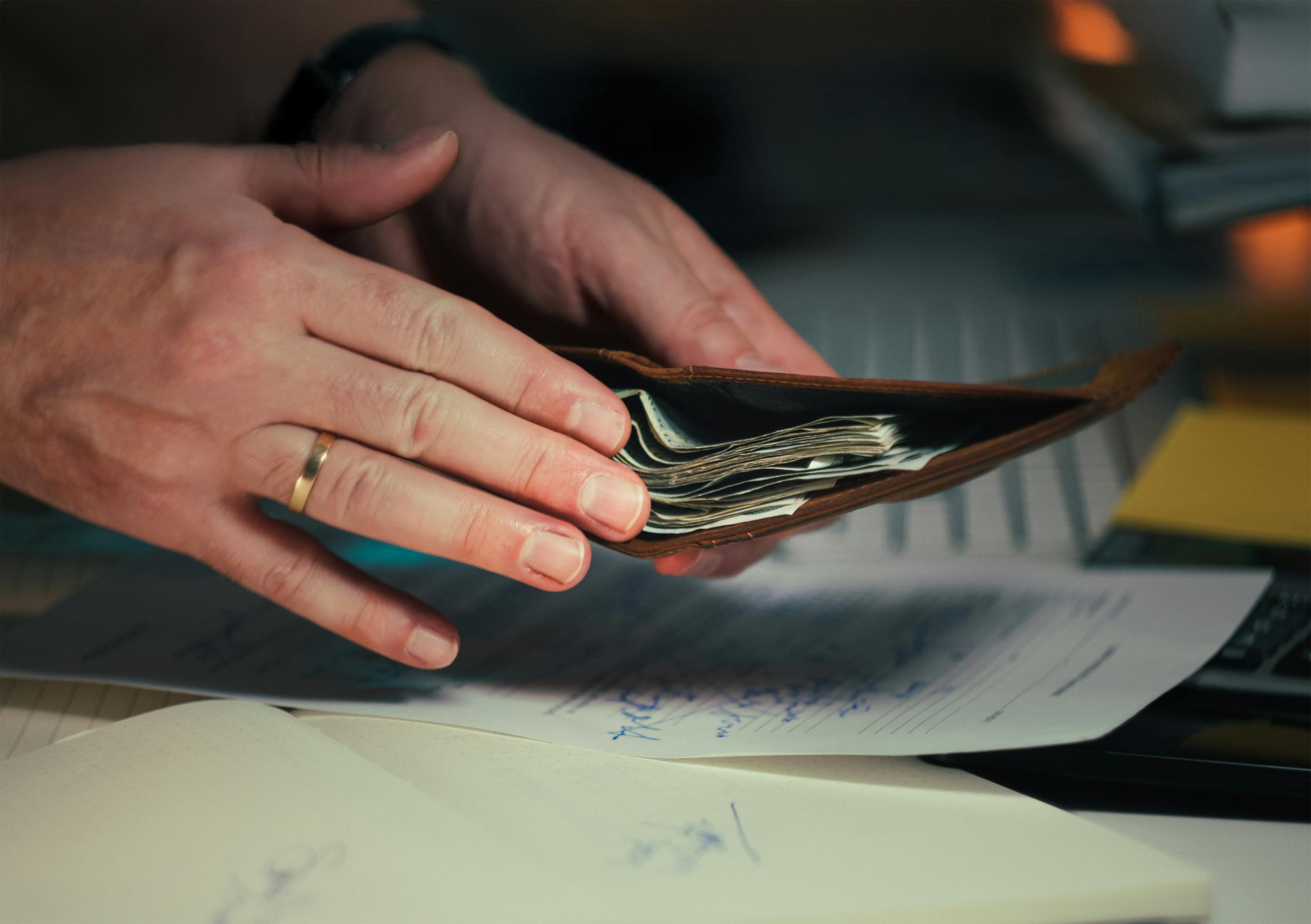 https://www.pexels.com/de-de/foto/nahaufnahme-von-handen-die-eine-geldborse-mit-bargeld-und-dokumenten-handhaben-34975636/
