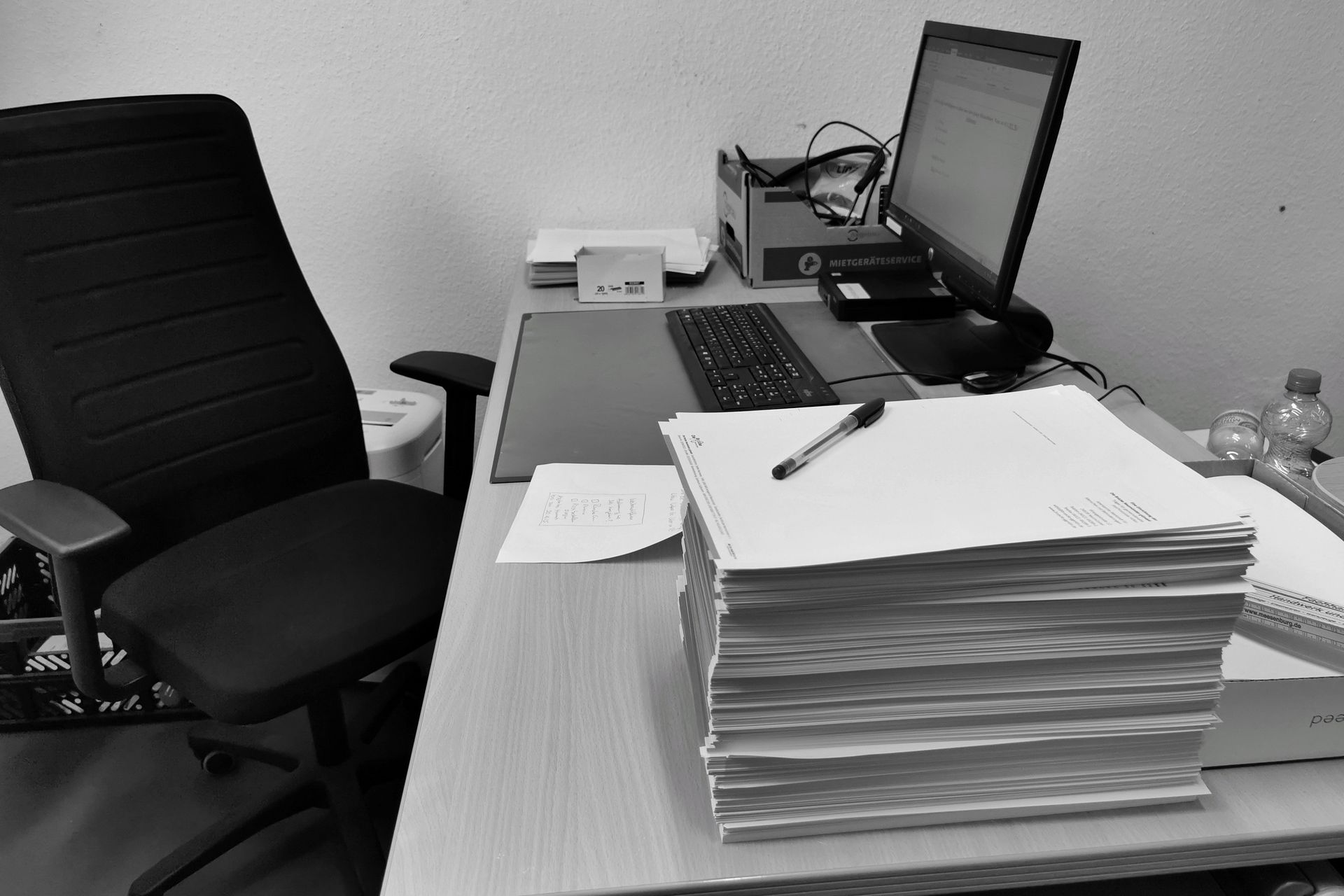 https://www.pexels.com/de-de/foto/monochromatischer-burotisch-mit-dokumenten-und-computer-34369598/