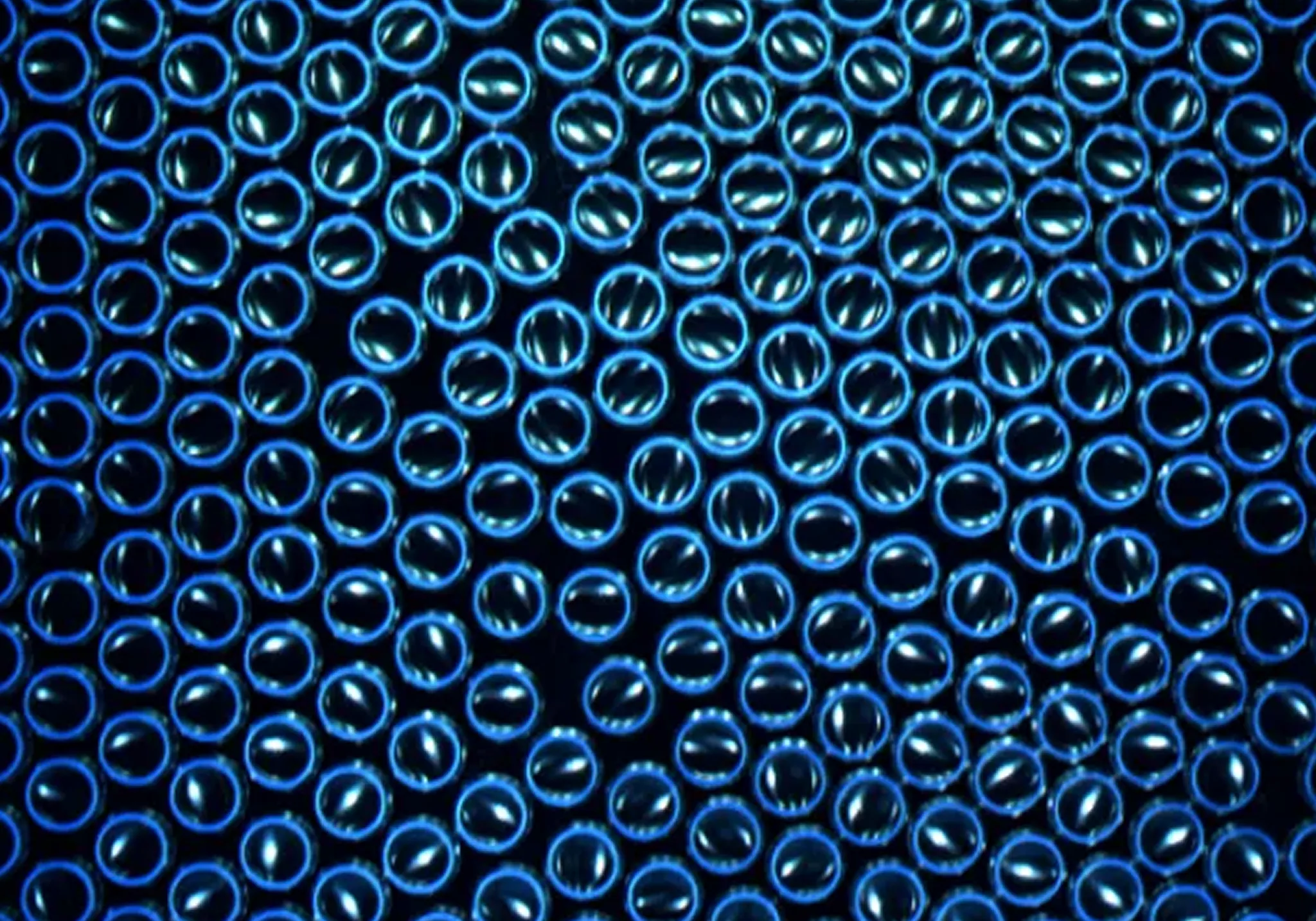 UVBC Inspection system view: aluminum cans with the bottom rims illuminated under ultraviolet light.