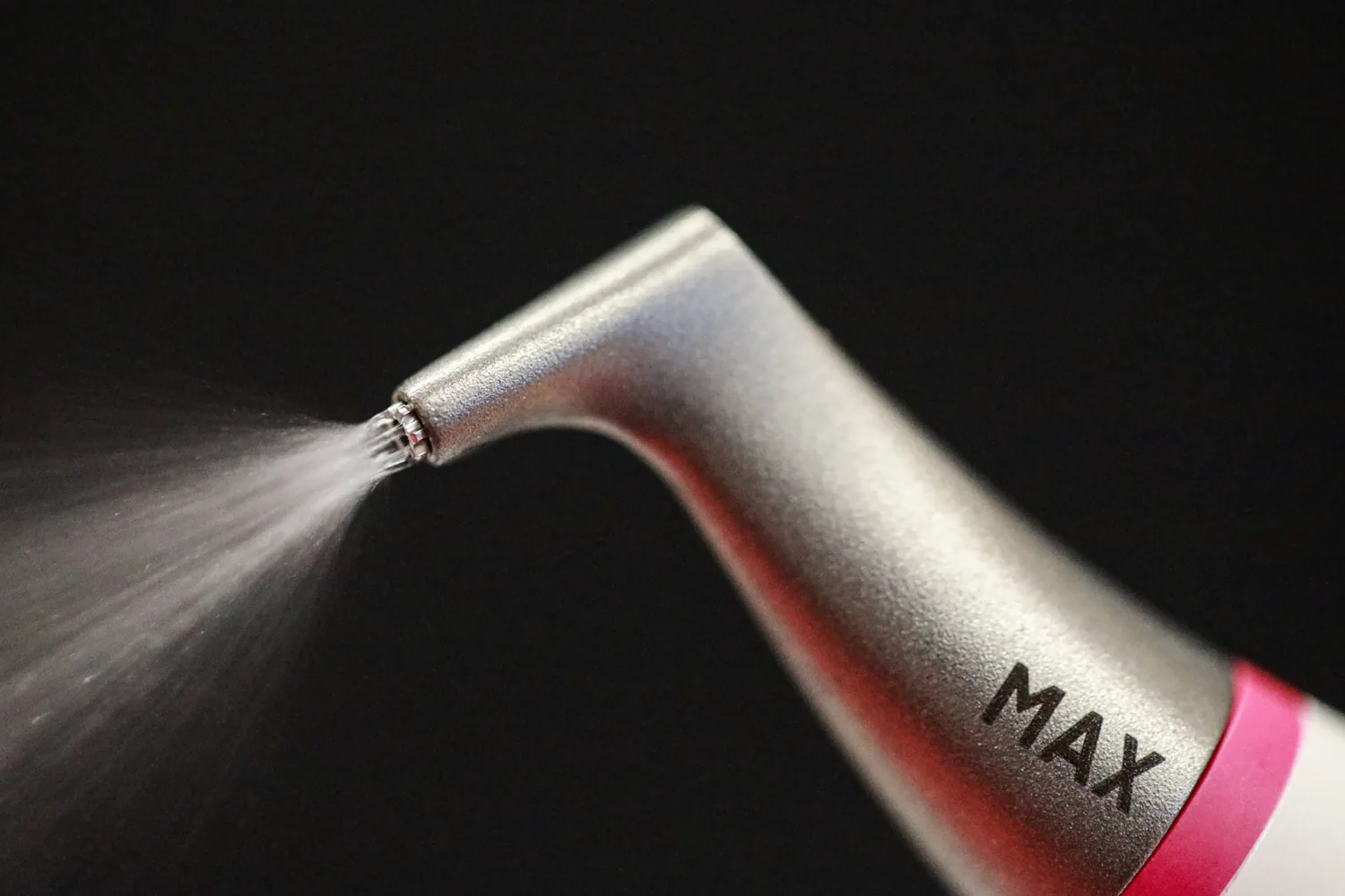 EMS AIRFLOW MAX nozzle dispensing a fine spray for Guided Biofilm Therapy