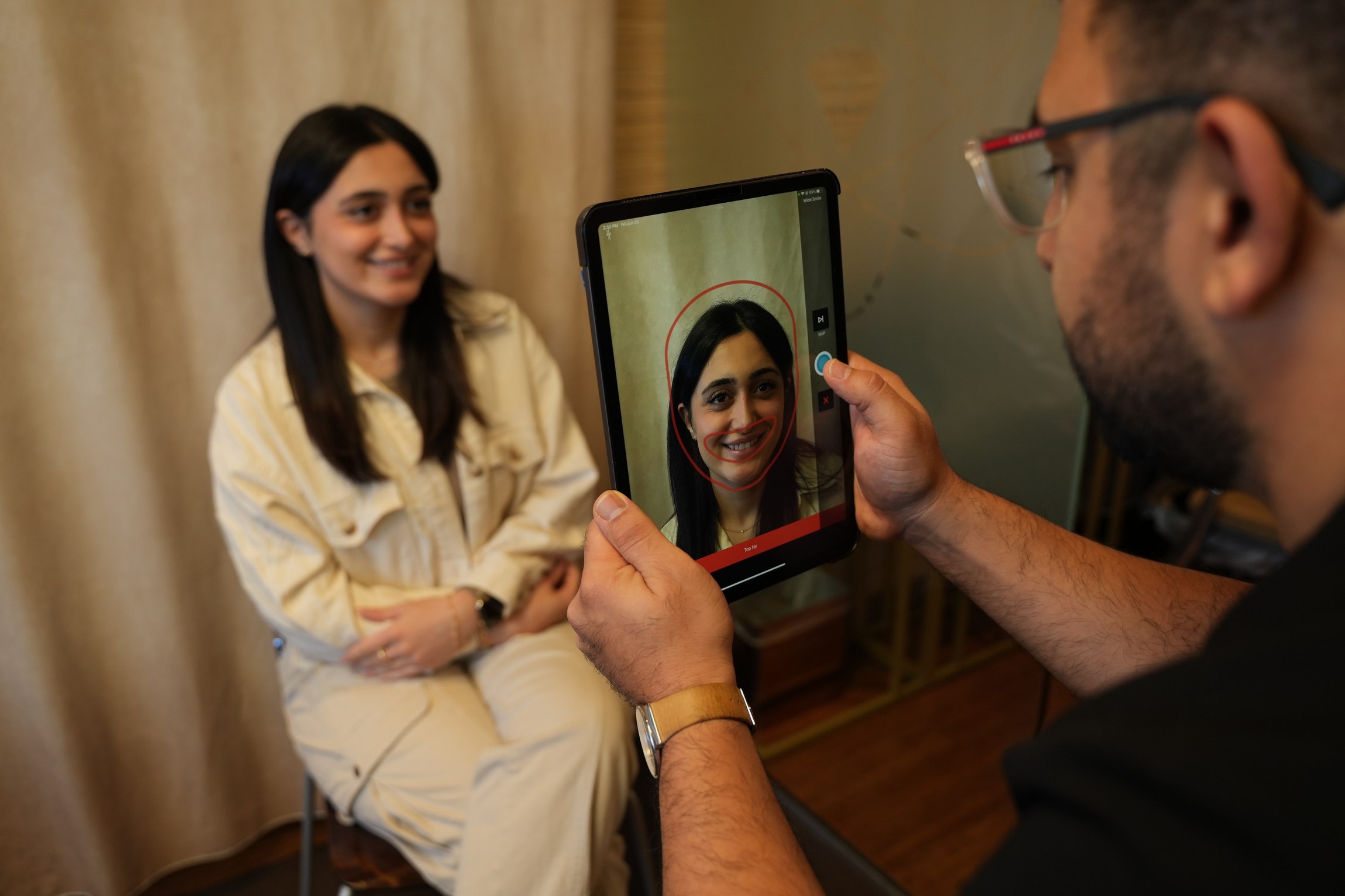 Dr. Raufy reviewing a patient's smile on a tablet during a consultation at Flawless Dental Studio.
