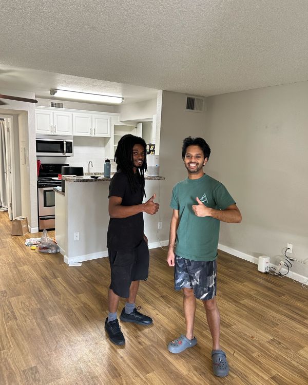 Movers standing inside empty student apartment after completing college move-out with Thumbs Up Moving Labor.