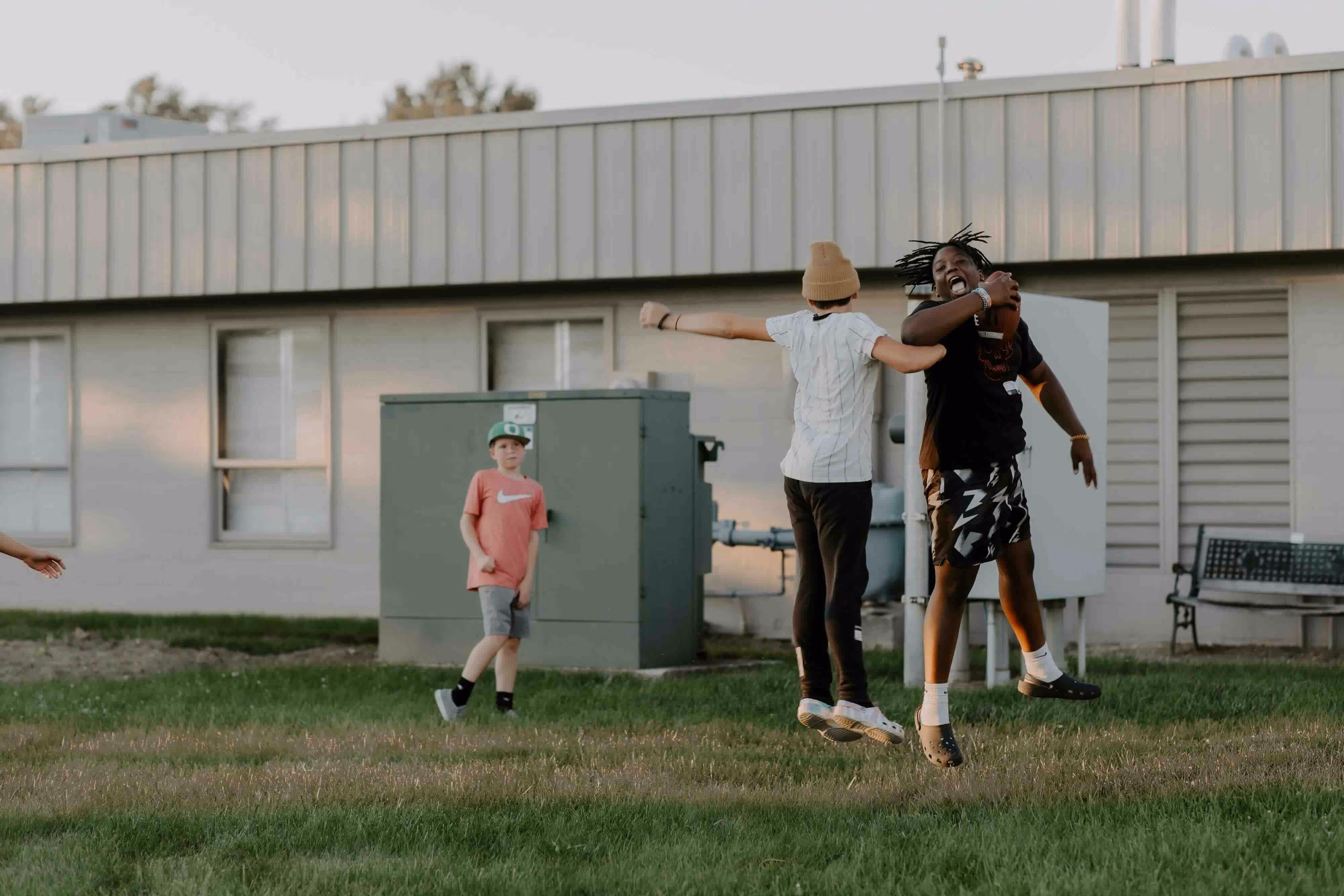 Two young people jumping in celebration playing football