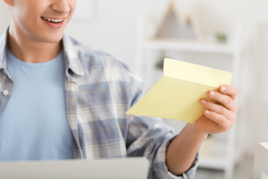 Donor to a nonprofit opening a handwritten thank you note sent by the organization