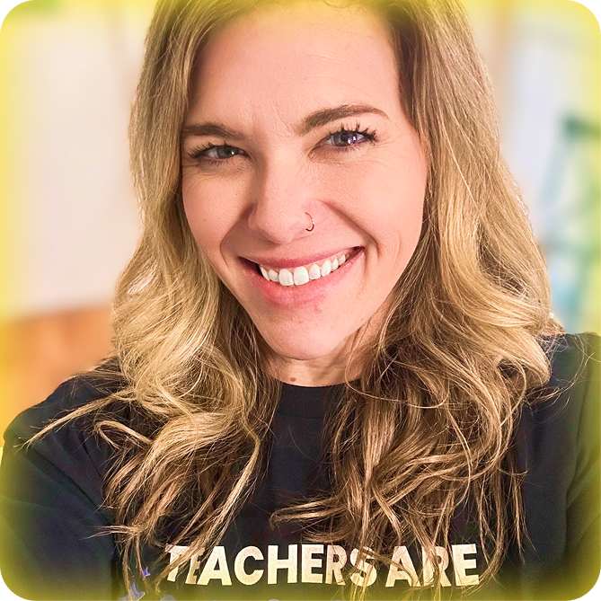 Image of a female teacher with blonde hair smiling and wearing a black Teachers Are Magic t-shirt.