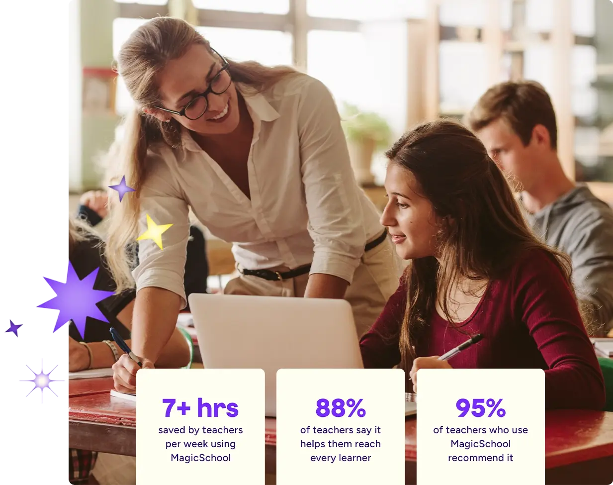 A teacher leans over a student’s desk, smiling as they look at a laptop together in a classroom. Other students work in the background