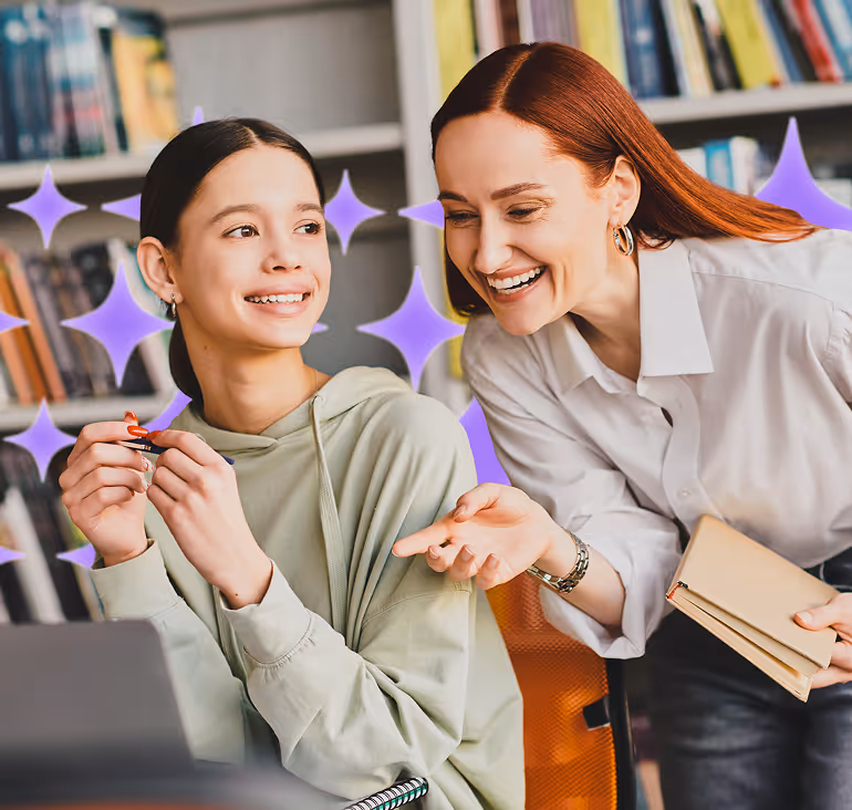 Teacher smiling and collaborating with a student at a desk, offering guidance beside a laptop in a library setting, with star accents symbolizing encouragement, support, and personalized learning.