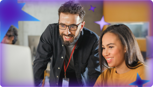 A teacher and student smile together while looking at a screen, collaborating in a modern classroom environment.