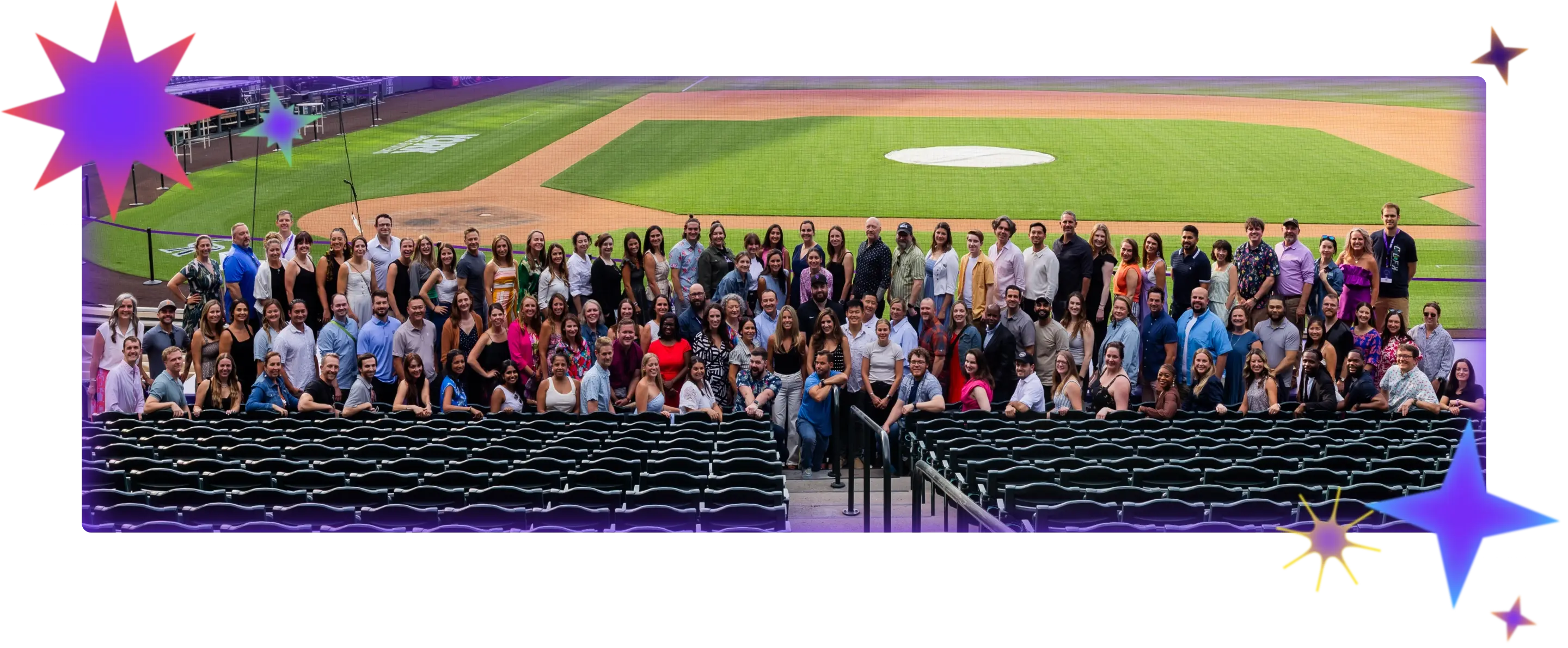 A photo from July 2025 of the full MagicSchool team posing for a company photo in front of the Colorado Rockies field during a company retreat.