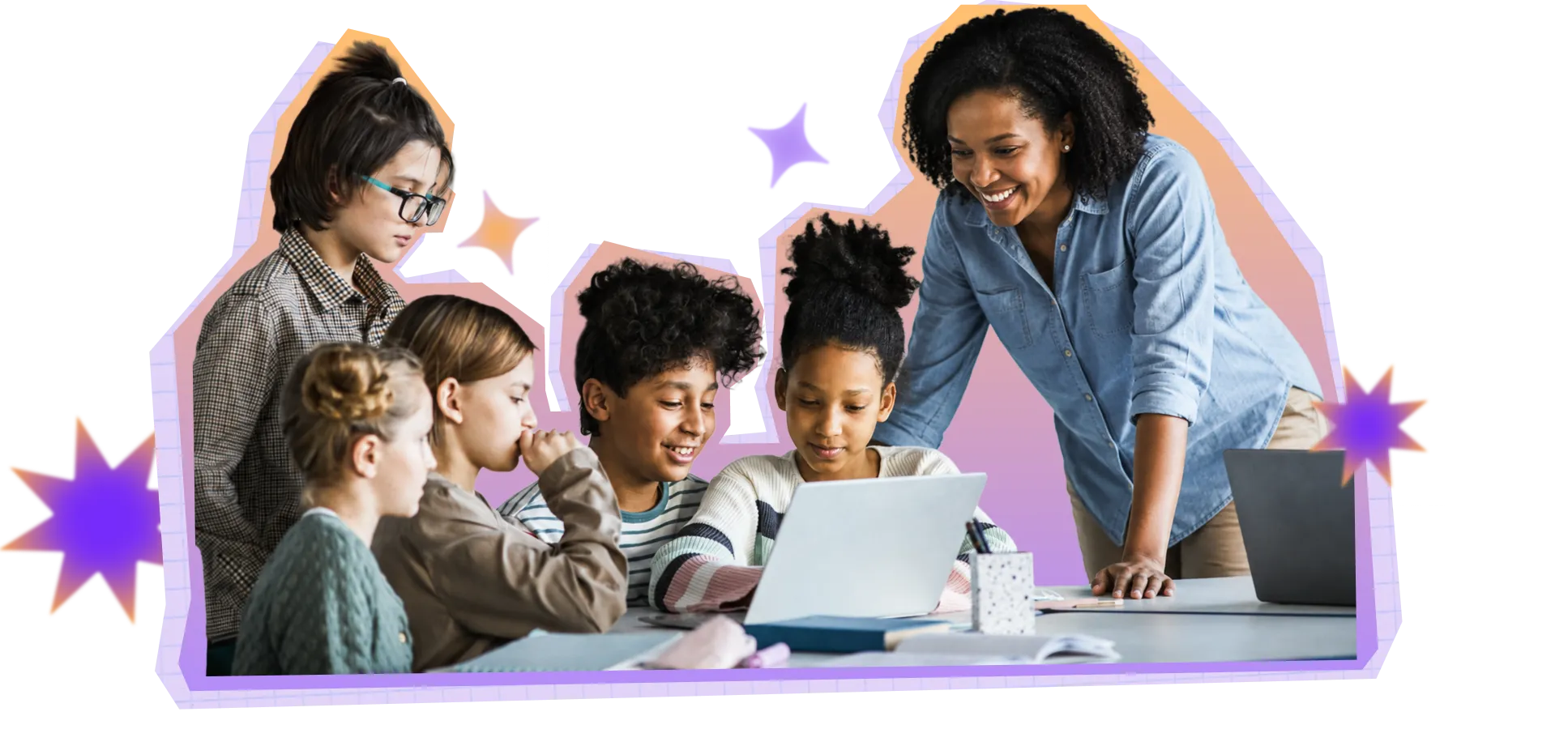 Photo of a teacher smiling and working with a group of 5 students a table in a classroom setting. 