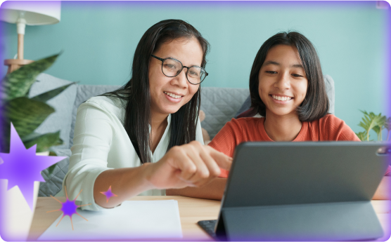 Teacher and student sitting at a desk using an ipad together 