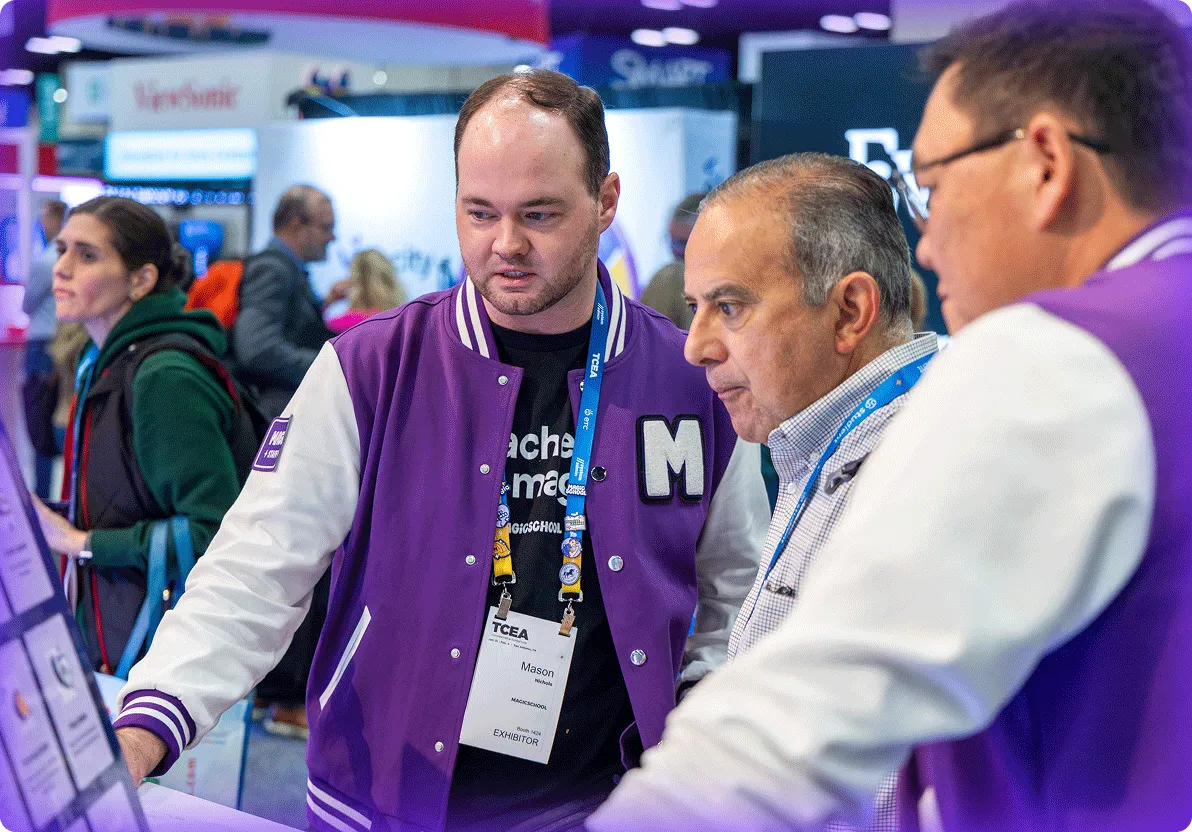 MagicSchool employee in a purple letterman's jacket demo'ing the MagicSchool app to an educator at a trade show