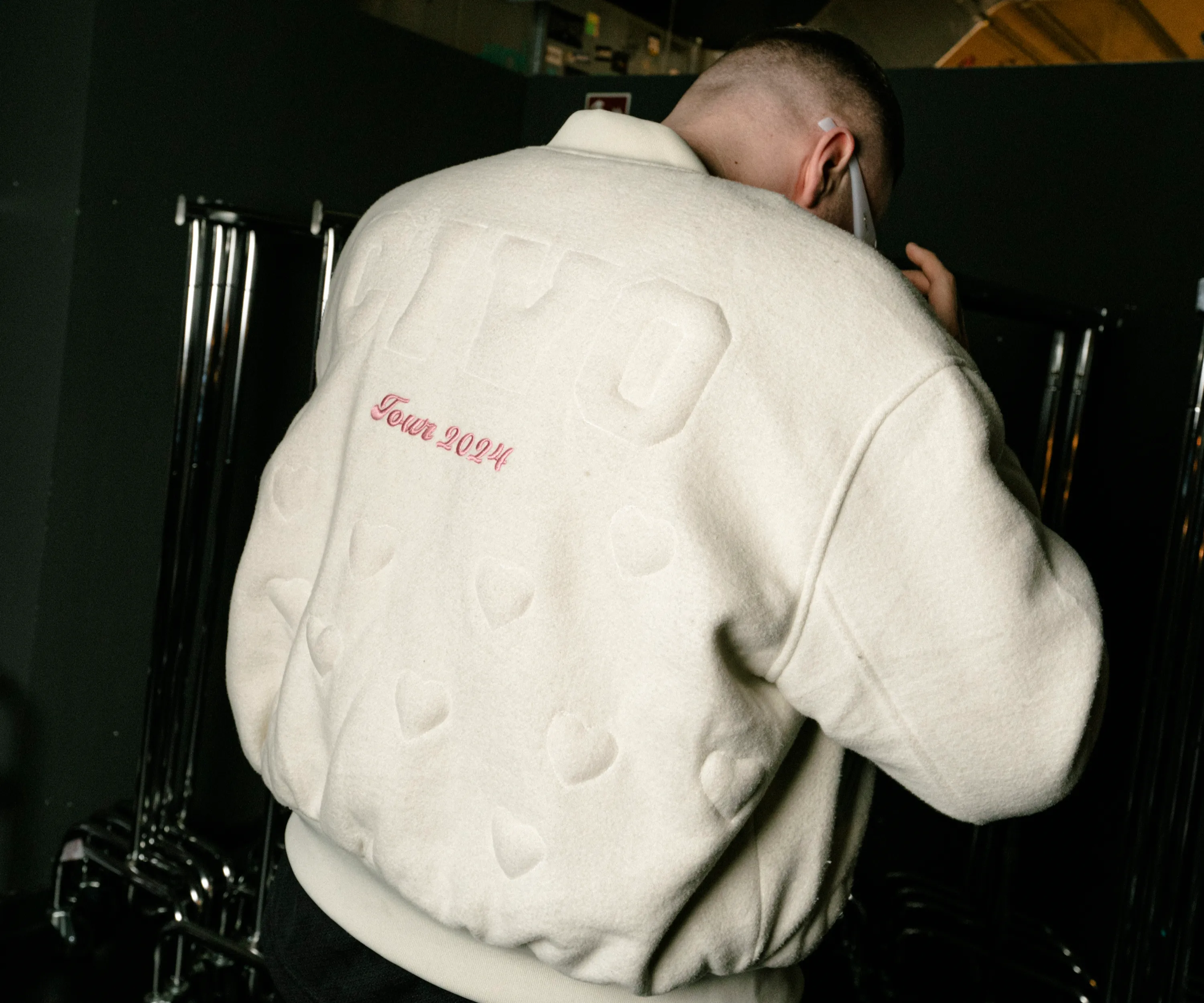 Civo von hinten im hellen College Jacke während des Konzertabends im Club Volta in Köln.