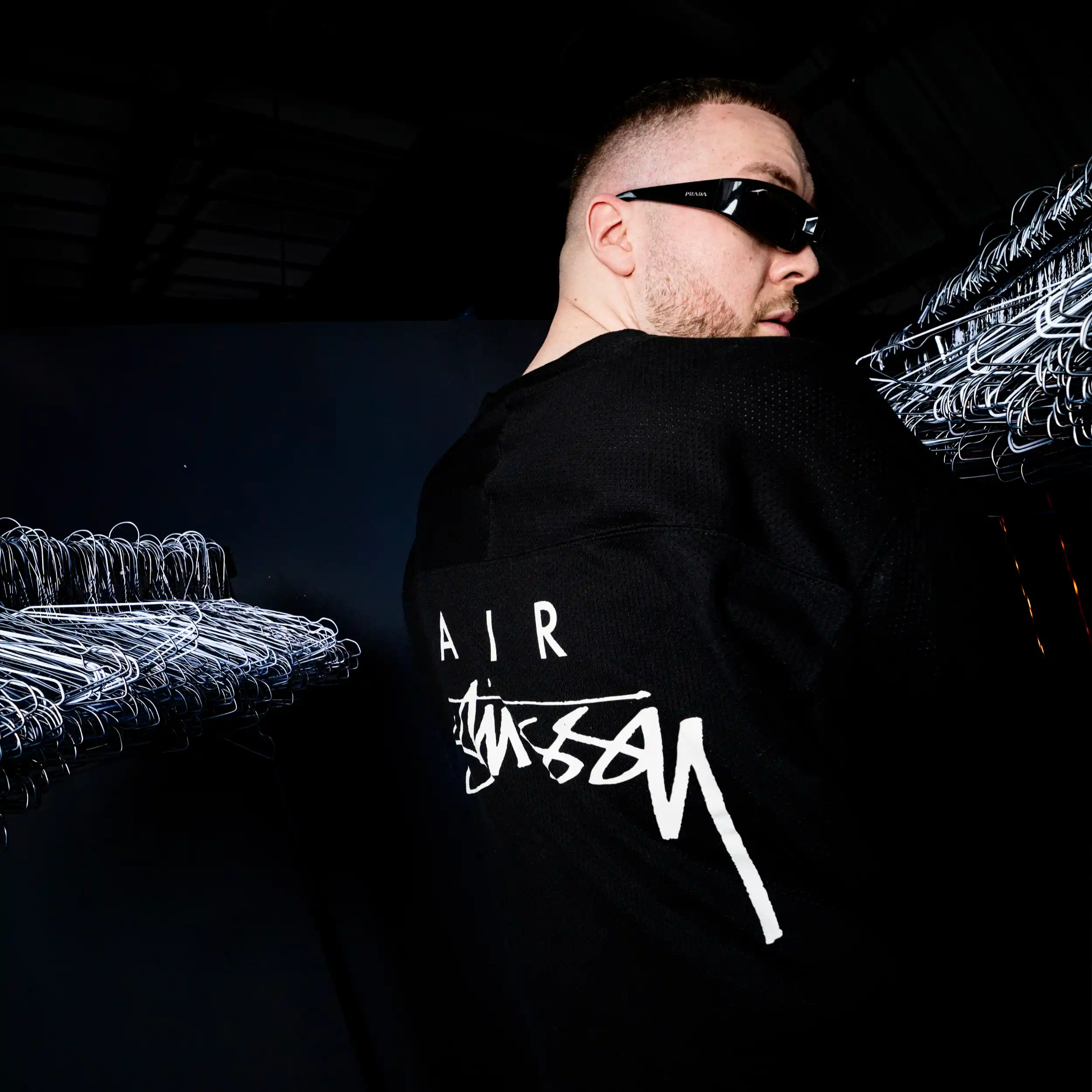 Civo von hinten im schwarzen Longsleeve mit weißem Aufdruck während des Konzertabends.