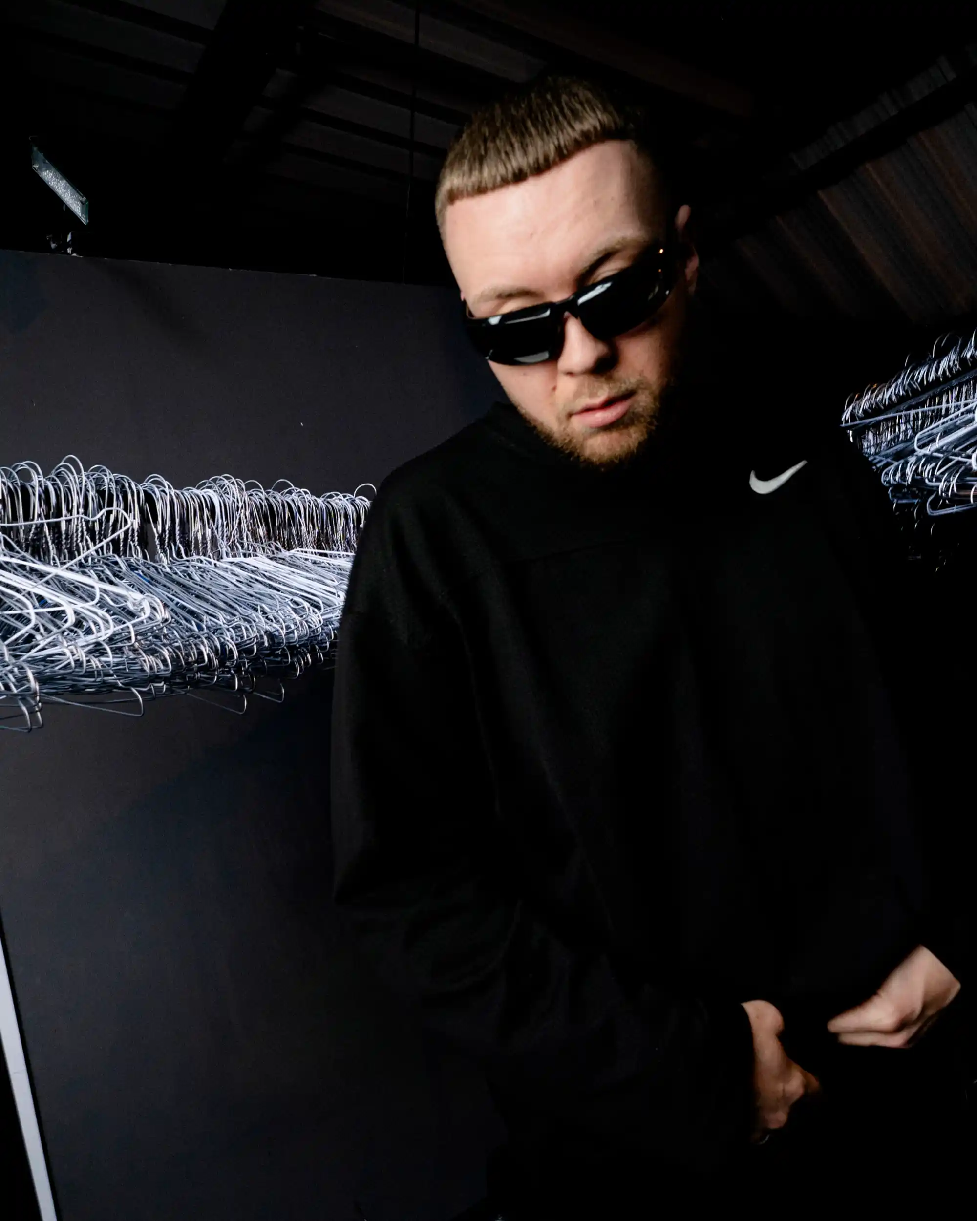 Civo mit Sonnenbrille und schwarzem Longsleeve in einem dunklen Porträt vor dem Auftritt.