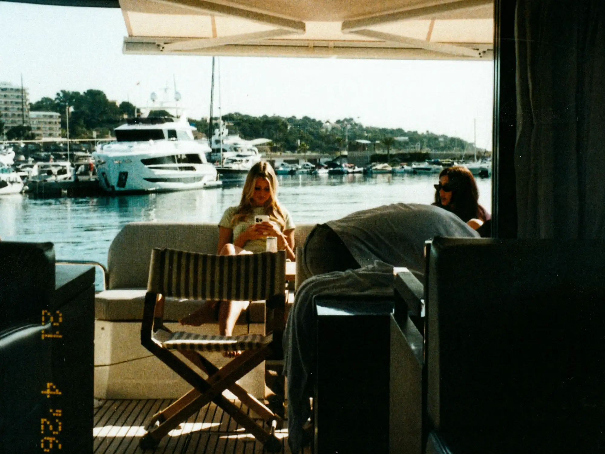 Blick aus dem Innenraum der Yacht auf das Sonnendeck mit dem Shootingteam und den Hafen im Hintergrund.