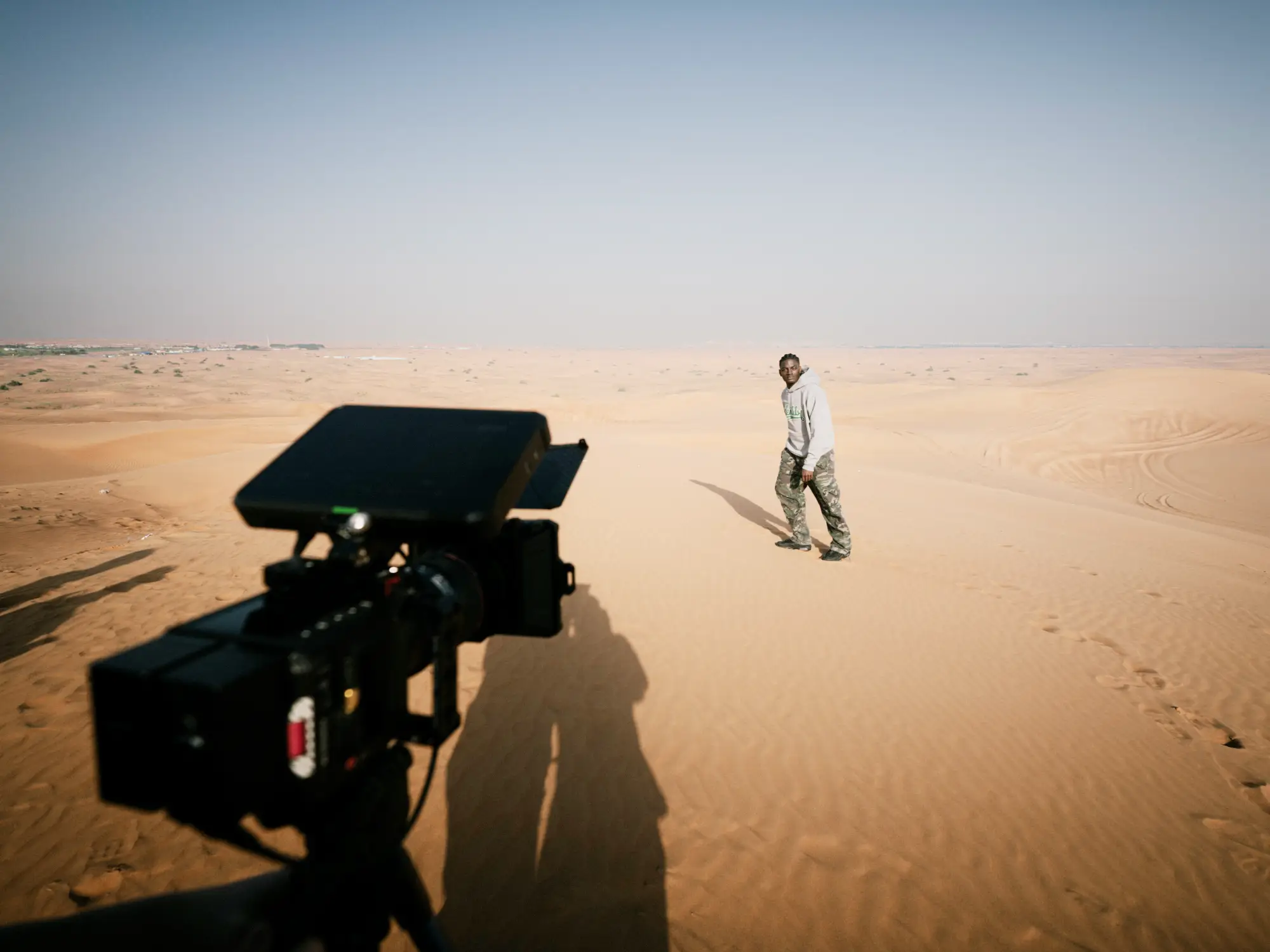 Kamera im Vordergrund und Ibo Ouro-Bodi auf einer Sanddüne beim Certified-Identity-Shooting.
