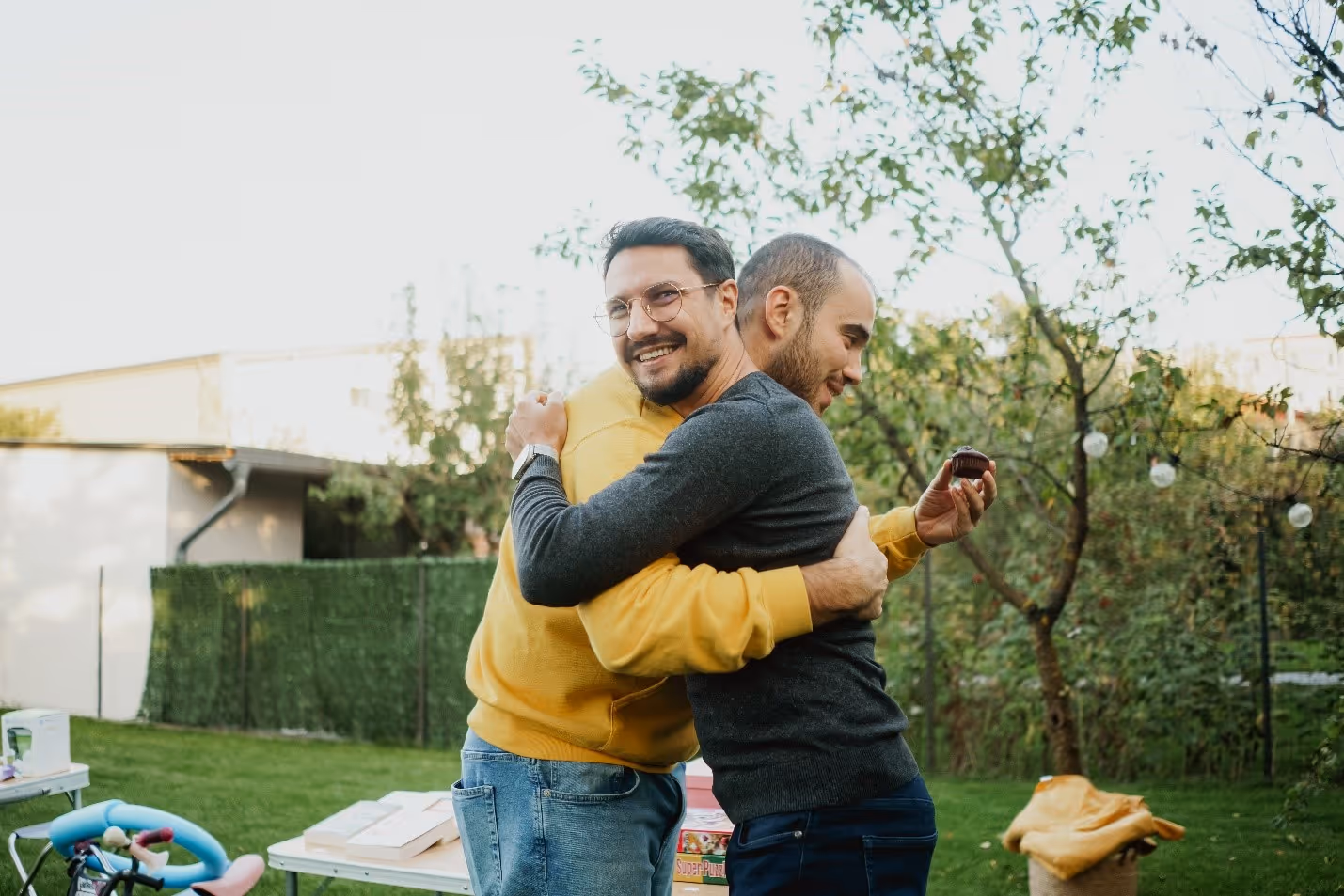 Two men hugging outsideDescription automatically generated