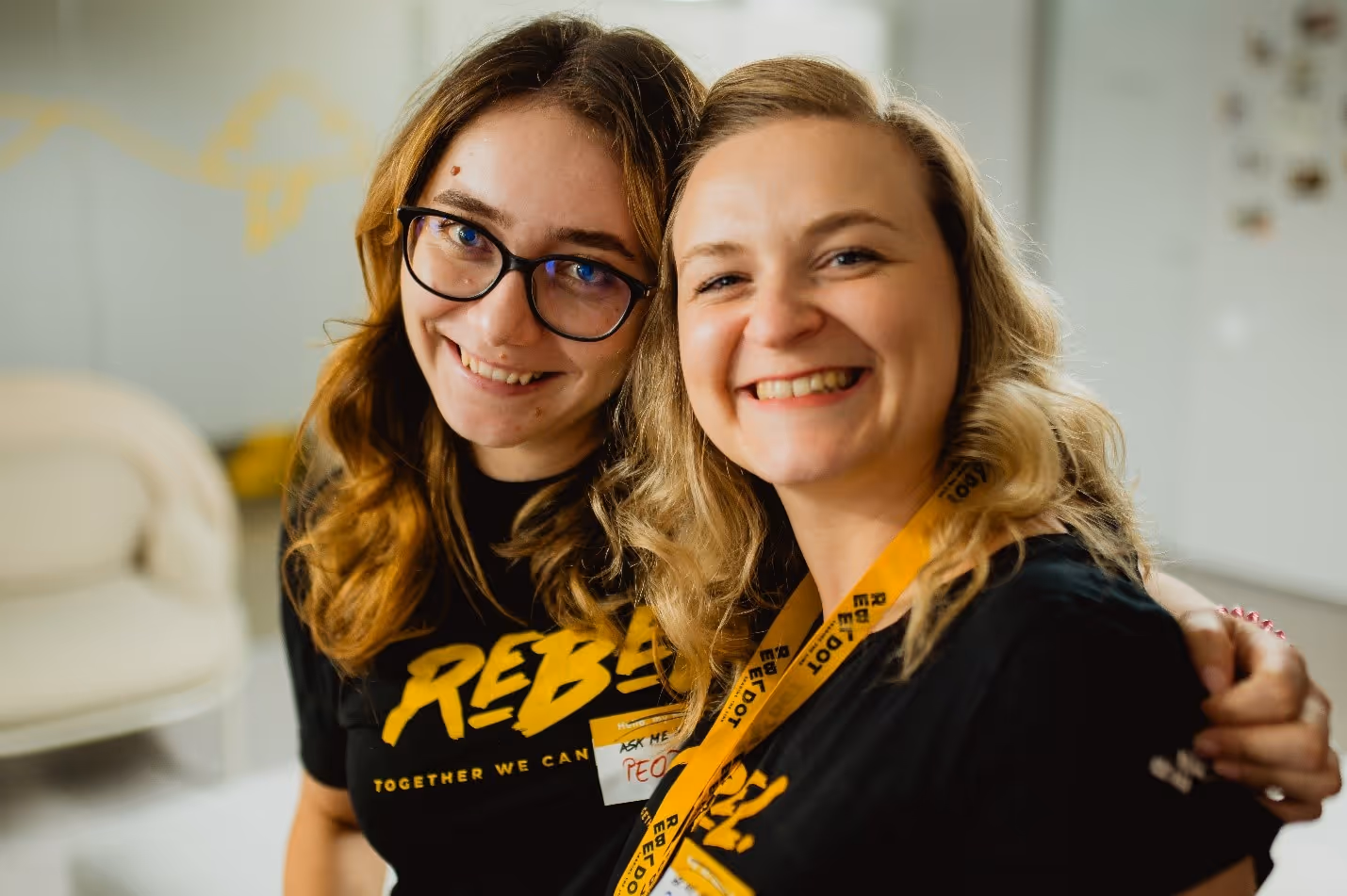 Two women smiling at the cameraDescription automatically generated
