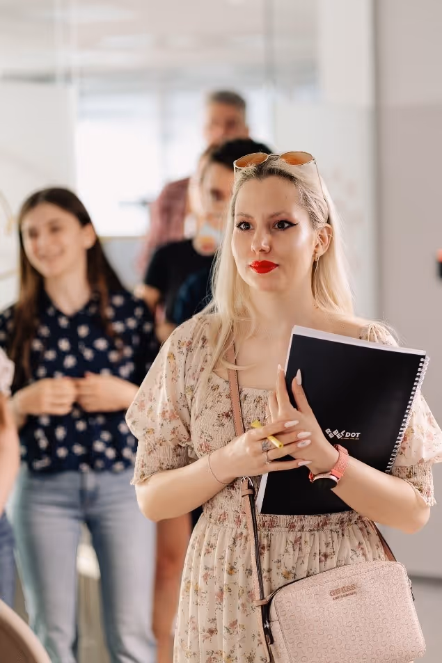 A person holding a book and smilingDescription automatically generated