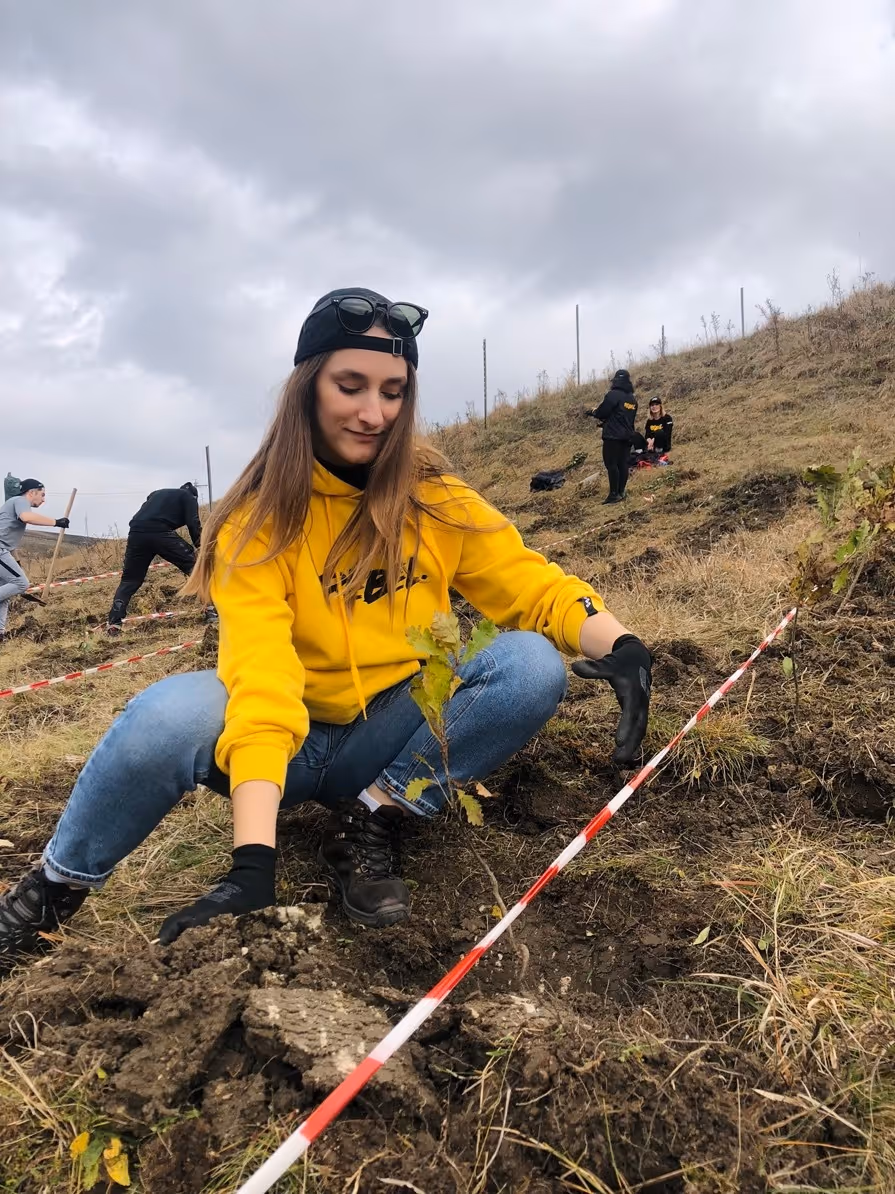 A person squatting on a hillDescription automatically generated