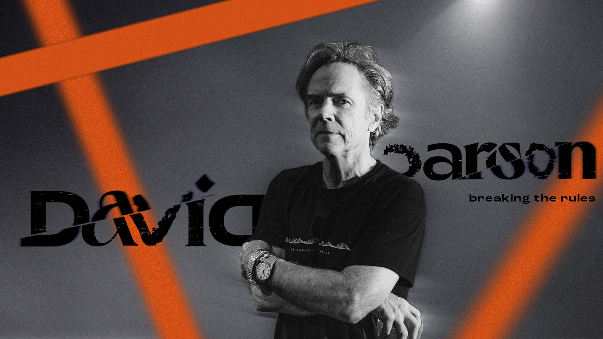 Black and white photo of a David Carson with crossed arms wearing a watch and bracelet, with orange diagonal streaks and text 'David Carson breaking the rules' in the background.