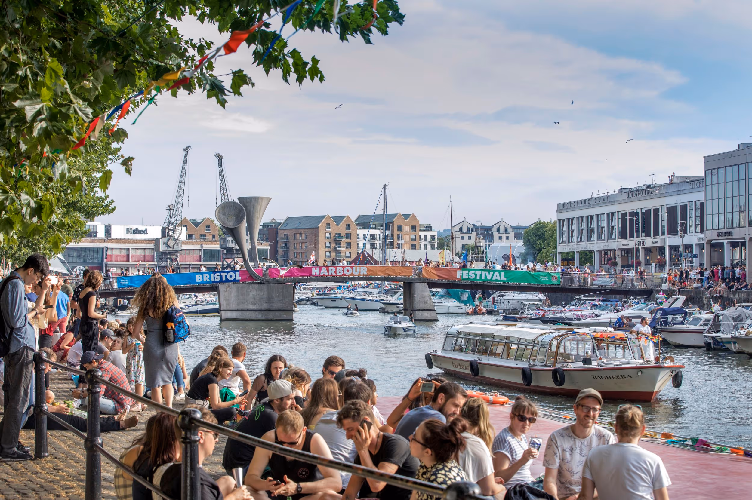 Crowds of people watching Bristol harbour