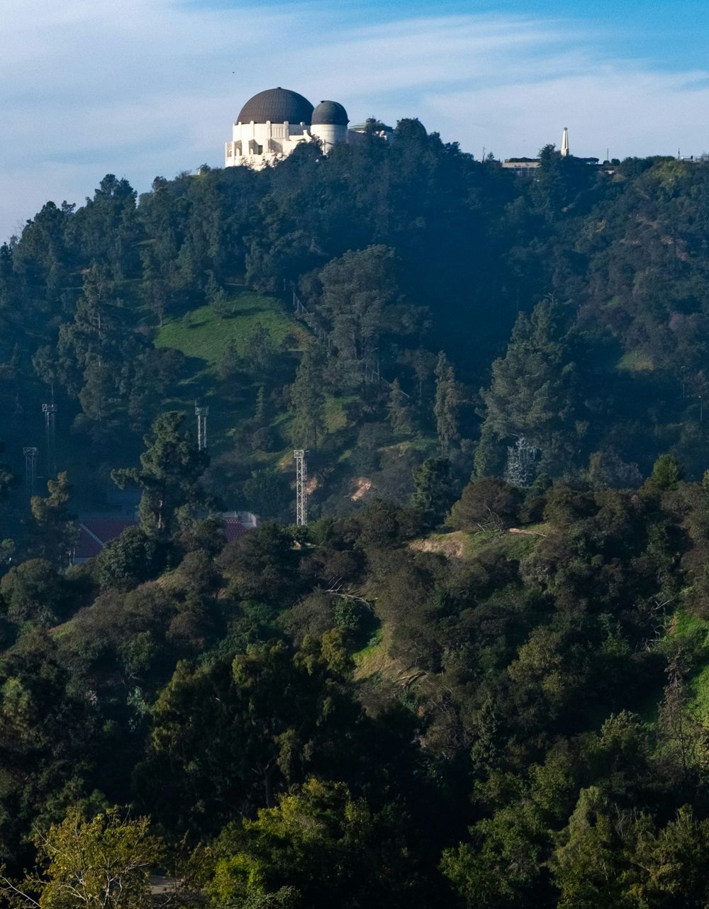 Griffith Observatory on its ridge above the green, tree-covered hills of Griffith Park