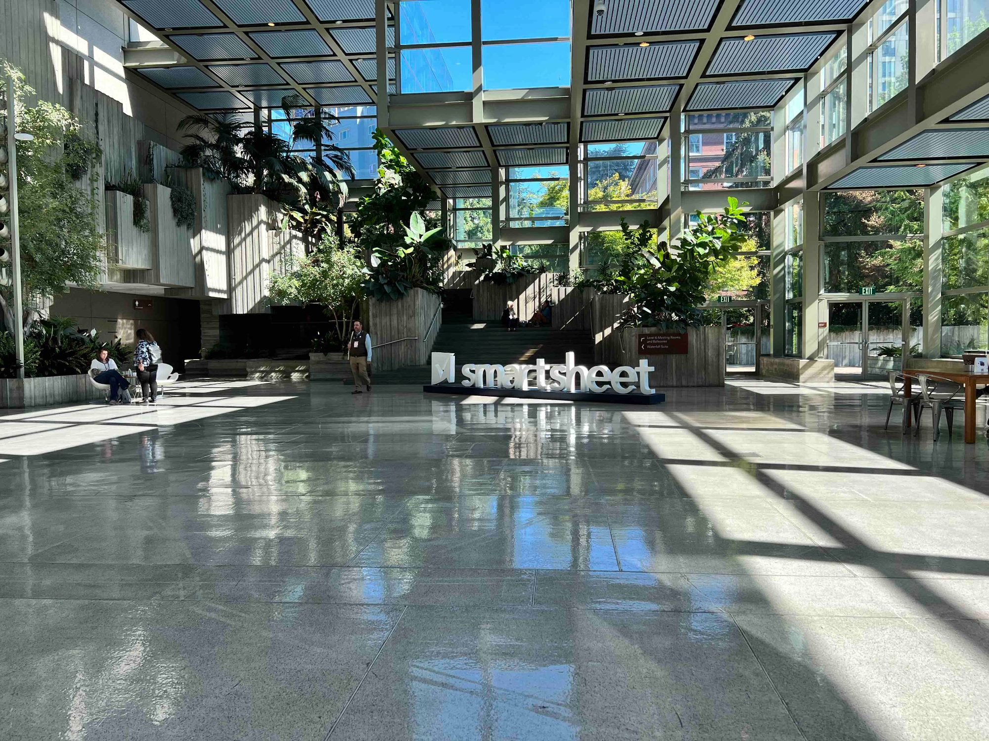 Smartsheet signage in a sunlit glass atrium in Seattle