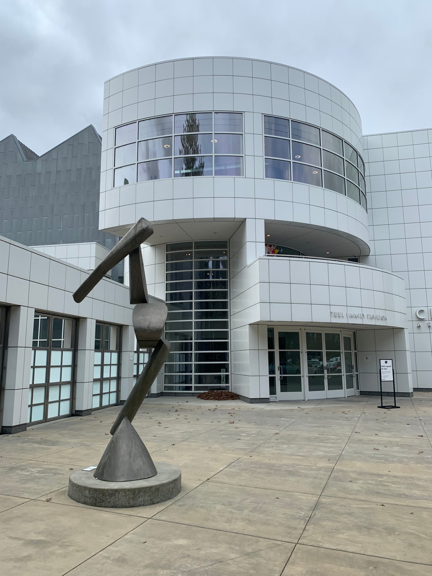 The curved white front of the Crocker Art Museum's modern wing in Sacramento, with an abstract bronze sculpture on the plaza