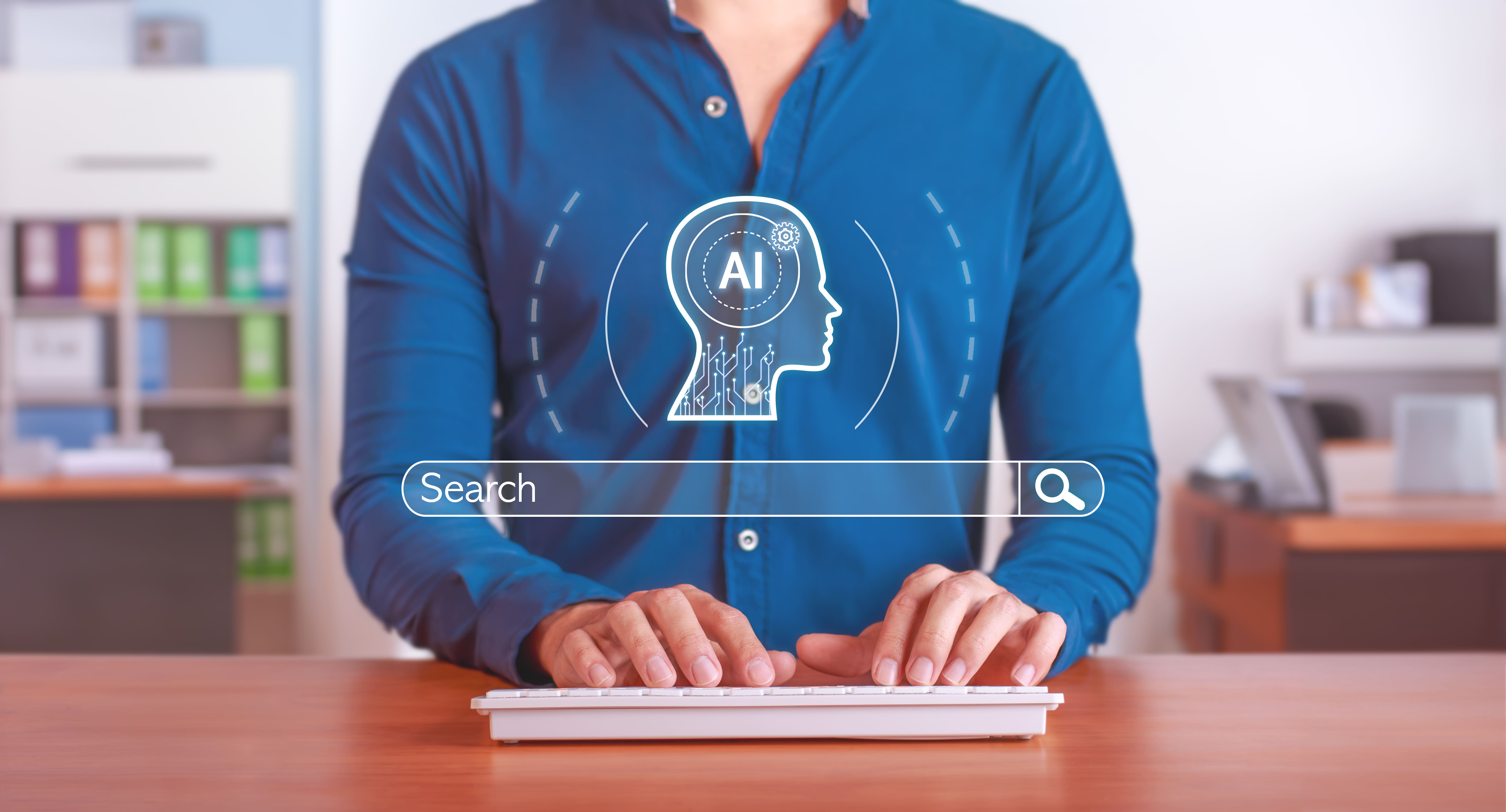 Professional typing on a keyboard at a desk with an illuminated digital overlay featuring an artificial intelligence head profile and a search bar icon.